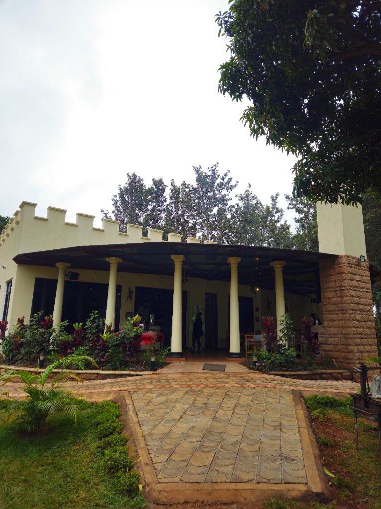 Un edificio con vestíbulo cubierto, columnas y un camino de piedra que conduce a la entrada.