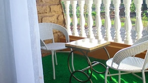 A balcony with a stone wall, white balustrade, wicker chairs, and a small table. - Samarine Resort & Spa Maragua (Maragua)