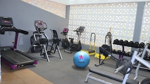 A gym with treadmills, elliptical machines, a stationary bike, a rowing machine, and a set of dumbbells. - Samarine Resort & Spa Maragua (Maragua)