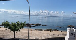 A coastal view with a clear sky, a sandy beach, and a white building with 'Año 1932' on it. - The Casa da Fonteseca Wake up facing the sea (Ribeira)