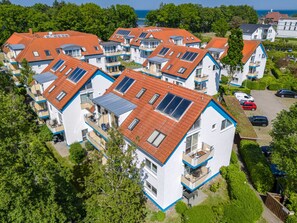 A residential area with multiple two-story houses featuring red-tiled roofs and solar panels. - Residence Am Strand 1-16 (Zingst)