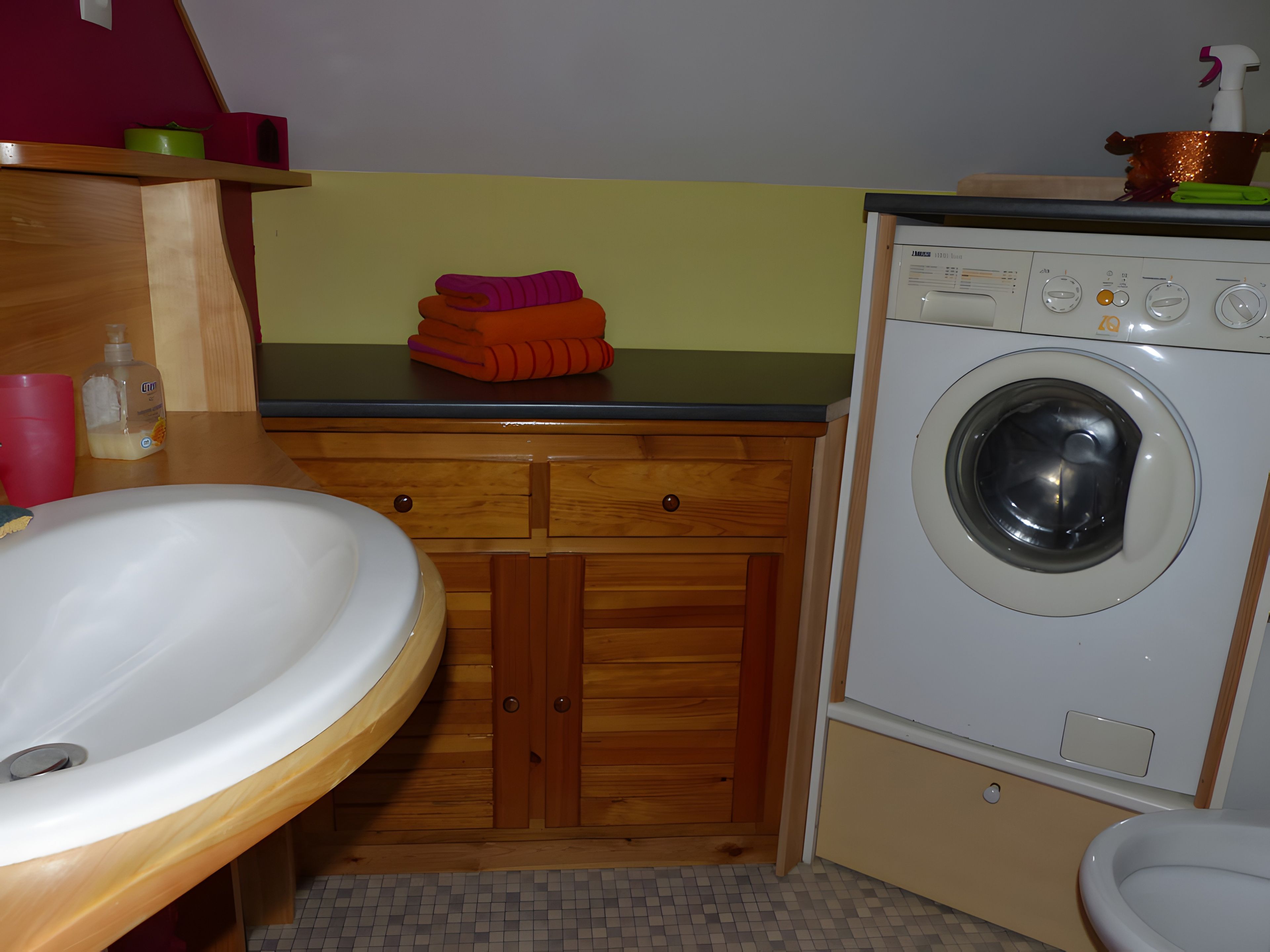 Une petite salle de bain comprenant un lavabo, des toilettes et un lave-linge.