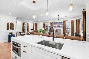 Een moderne keuken met een centraal kookeiland, een inbouwoven en een spoelbak.