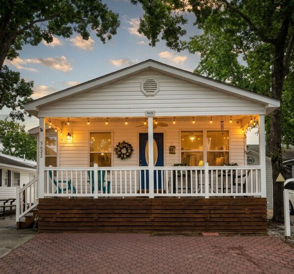 A white building with a porch, a wreath, and a number '5622' on the door.