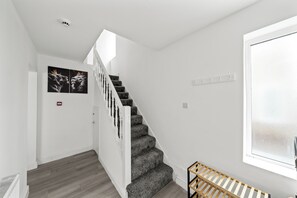 Eine Treppe mit weißer Geländer, eine Holzbank und ein Fenster mit Aussicht.