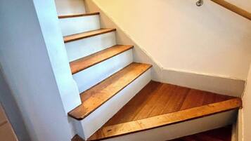 Eine Treppe mit Holzdielen und einem weißen Geländer.