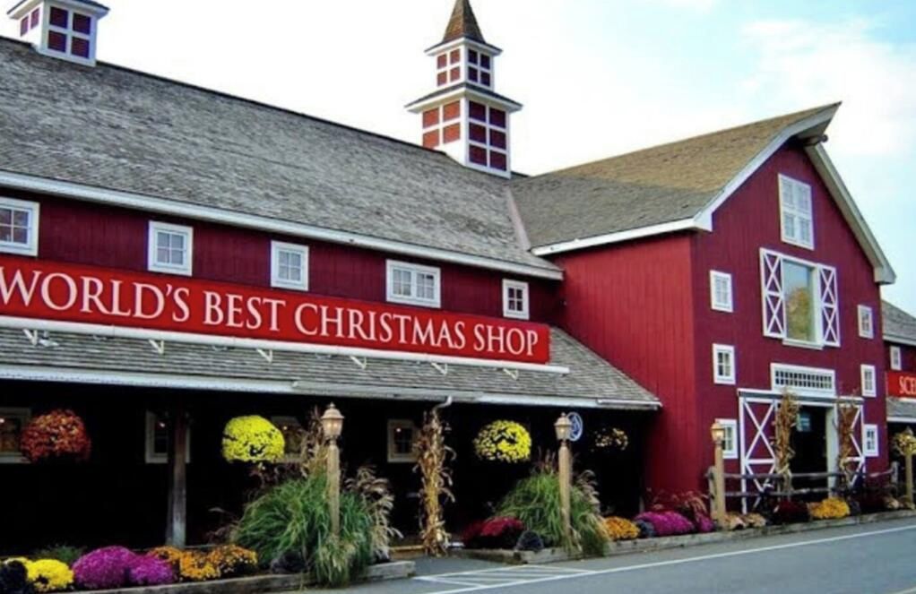 A red building with a sign that reads 'WORLD'S BEST CHRISTMAS SHOP.'