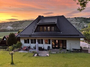 Ein Haus mit einem steilen Dach, einer Satellitenschüssel und einem gepflegten Rasen.