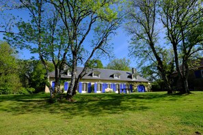 A two-story house with a sloped roof, surrounded by a well-maintained lawn and trees. - Spacious villa with private pool and panoramic views in the Morvan (Saint-Léger-de-Fougeret)