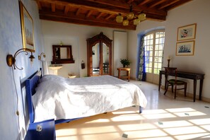 A bedroom with a bed, a desk, a chair, a mirror, and a window with curtains. - Spacious villa with private pool and panoramic views in the Morvan (Saint-Léger-de-Fougeret)