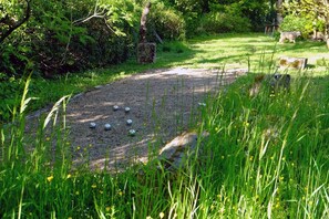 A gravel path with metal balls, surrounded by lush greenery and trees. - Spacious villa with private pool and panoramic views in the Morvan (Saint-Léger-de-Fougeret)