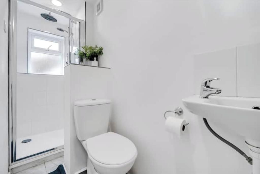 Ein Badezimmer mit Toilette, Waschbecken und Duschbereich.