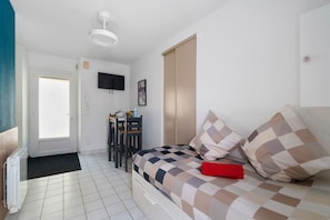 A bedroom with a bed, a desk, a chair, a television, and a radiator. - Studio with Port View, Perfect for Business Stays in Nort-sur-Erdre (Nort-sur-Erdre)