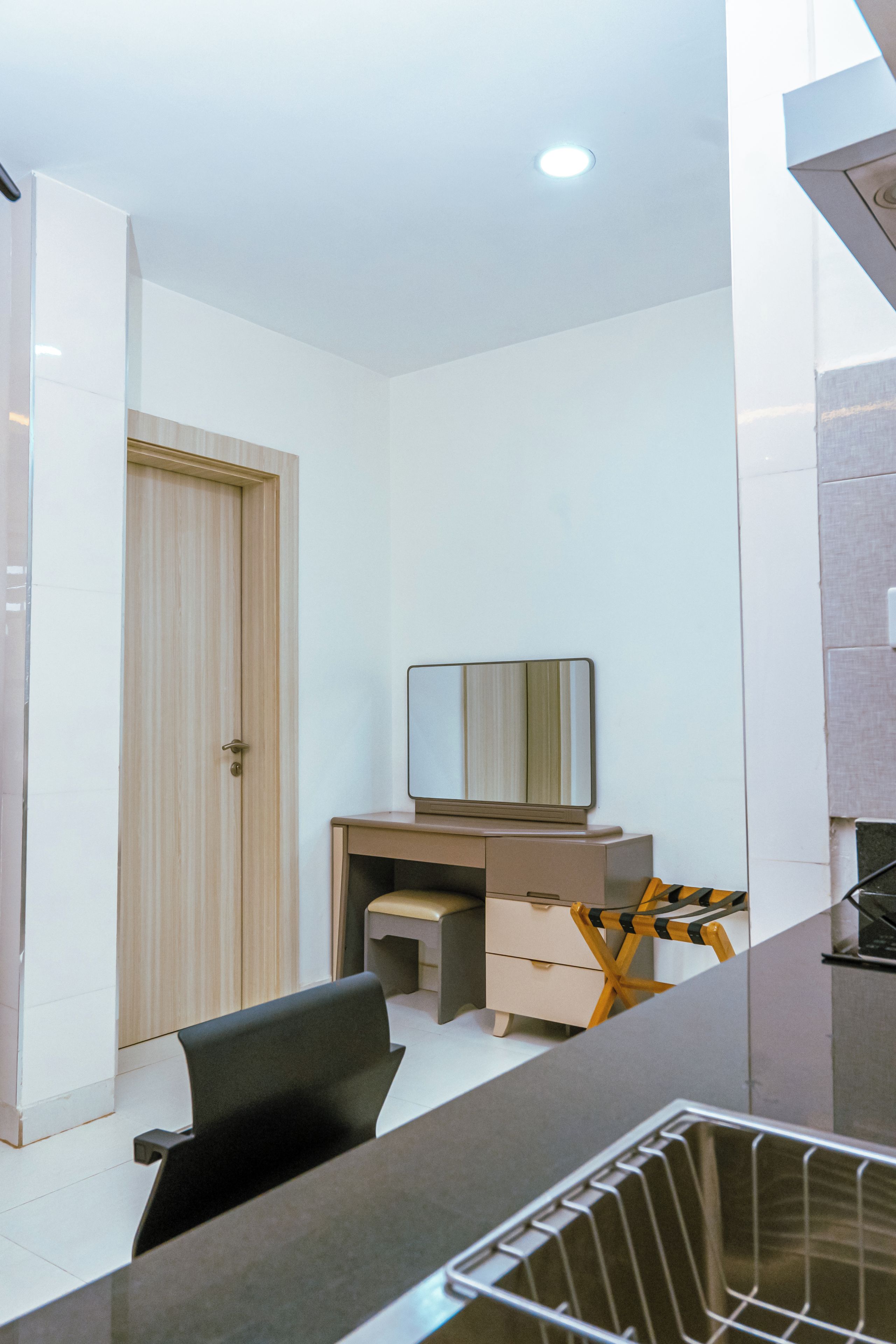Een moderne slaapkamer met een bureau, stoel en een garderobe.