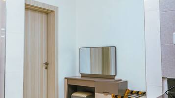 Een moderne slaapkamer met een bureau, stoel en een garderobe.