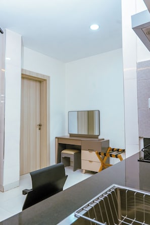 A modern bedroom with a desk, chair, and a wardrobe.