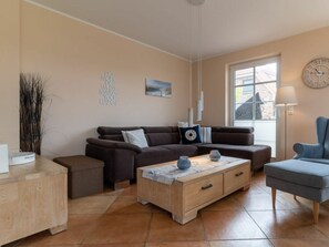 Ein Wohnzimmer mit einer Couch, einem Couchtisch, einem Beistelltisch und einer Lampe.