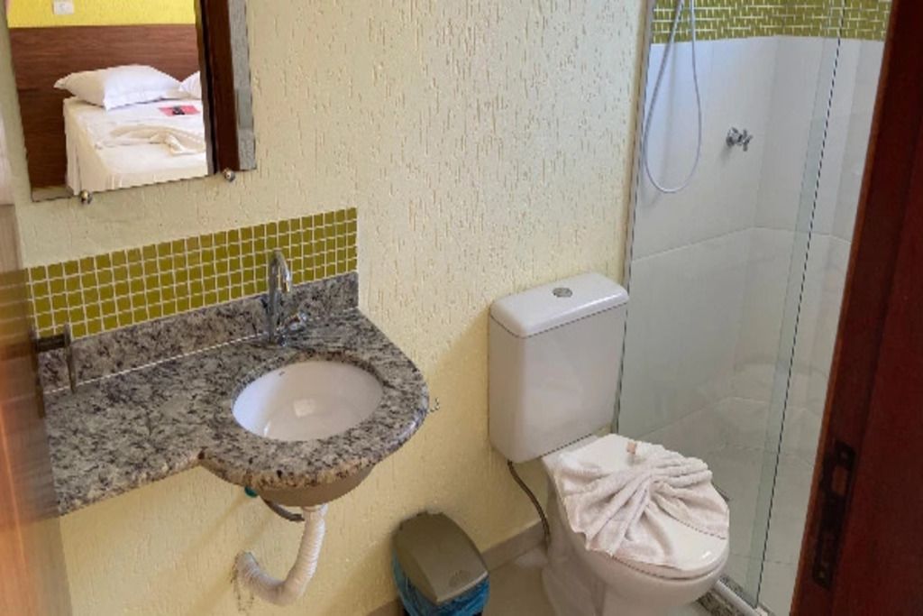 Un baño con lavamanos de granito, inodoro y ducha.