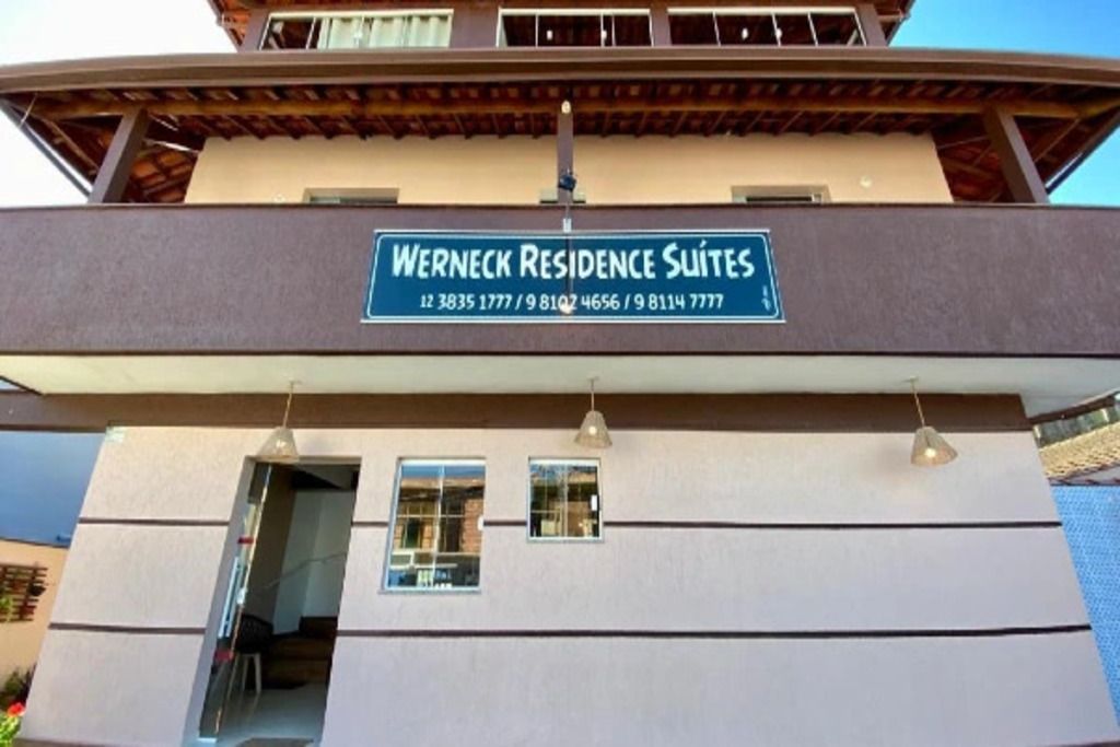 Een gebouw met een bordje waarop 'Werneck Residence Suites' staat, en contactnummers.