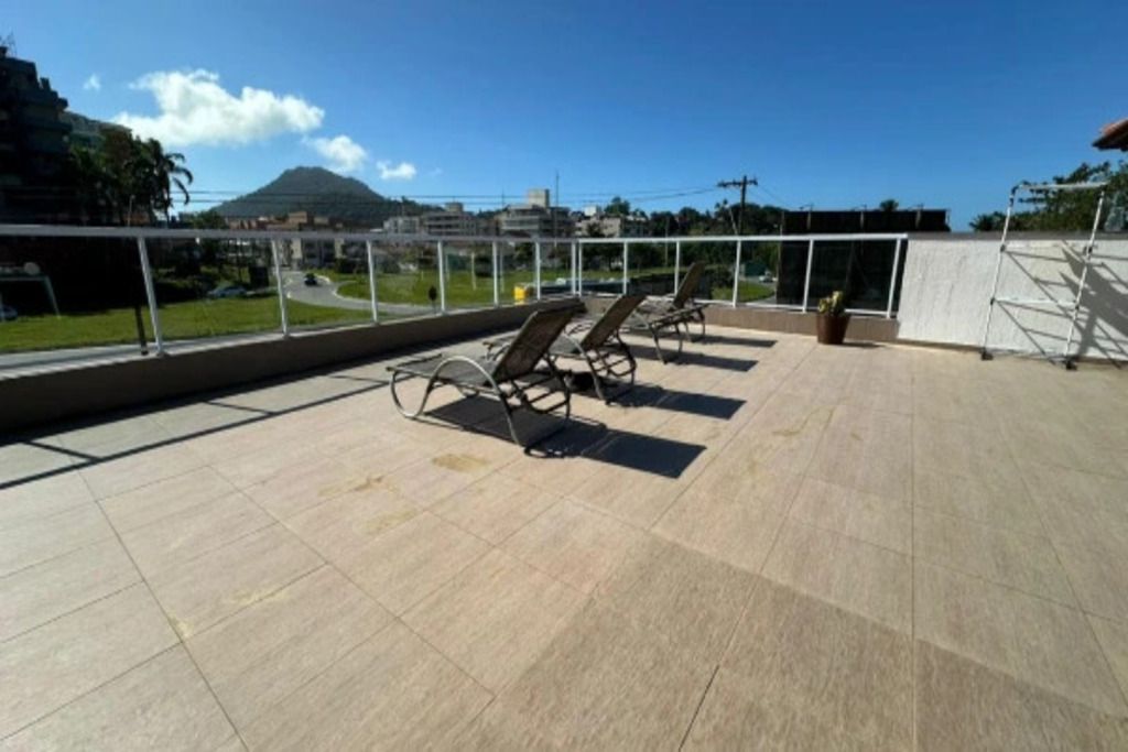 Een terras op het dak met ligbedden en uitzicht op een berg.