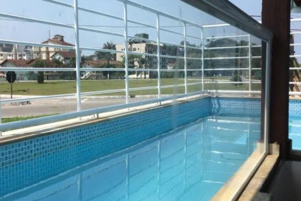Une piscine offrant une vue dégagée sur les environs grâce à une grande baie vitrée.