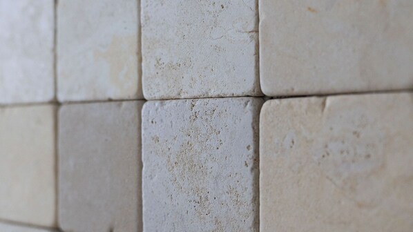 Detalhe de uma parede revestida de azulejos, com as juntas bem visíveis.