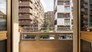 A multi-story residential building with balconies, a tree in the center, and a visible storefront with signage. - [Bocconi / Naviglio Pavese] Cozy Suite with 2 beds + Wi-Fi + A/C (Milano)