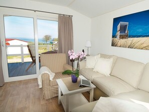 Ein modernes Wohnzimmer mit einer Couch, einem Sessel und einem Tisch mit einem Tablet.