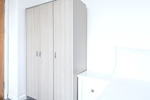 A room with a wardrobe, a bedside table, and a bed. - Roundhay Retreat – Family-Friendly Home + Parking - Pass the Keys (Leeds)