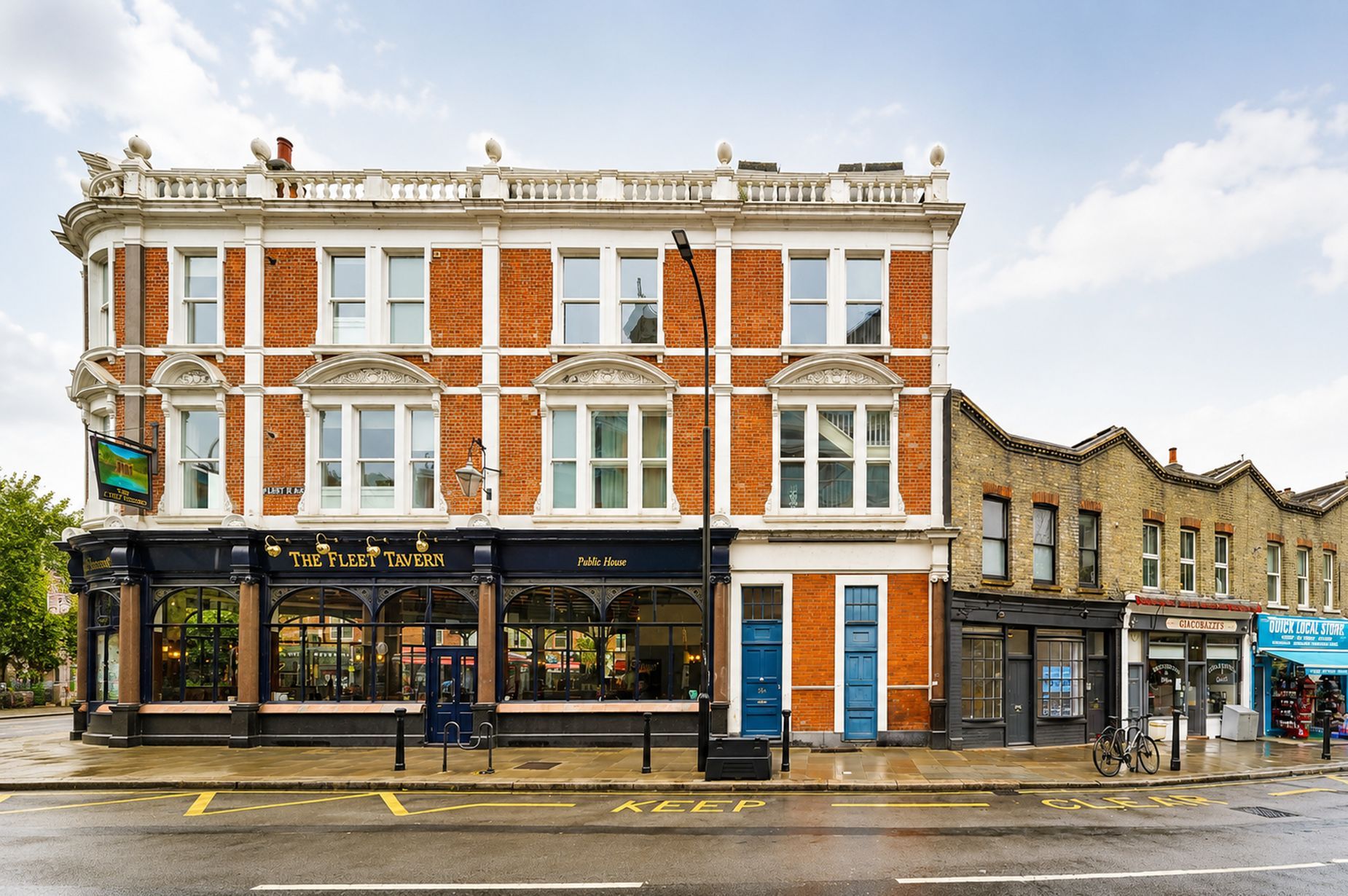 A corner building with a pub named 'The Fleet Tavern' and a 'Public House' across the street.
