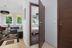 A modern living room with a sofa, a desk, and a dining area. - Cracow | aleja Kijowska 24 | Comfortable Apartment | Desk (Kraków)