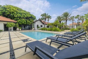 A poolside area with lounge chairs and a swimming pool. - Opal Luxury Estate | 6BR Villa, Private Pool & BBQ (Noord)
