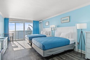 A hotel room with two beds, a balcony, a desk, and a view of the sea. - Oceanfront Sand Dunes Condo w/ Pools (Myrtle Beach)