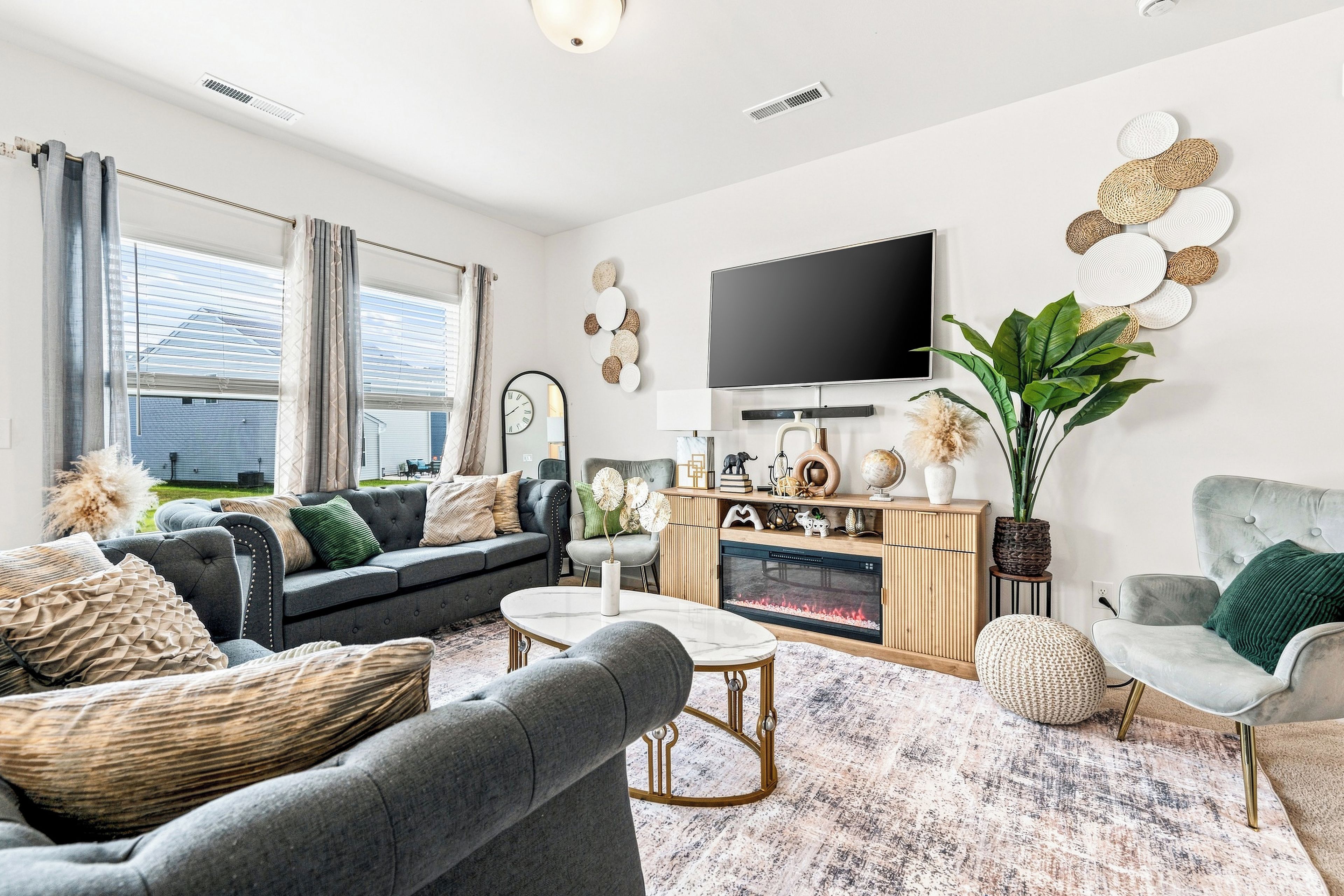 A modern living room with a grey sofa, a coffee table, and a flat-screen TV mounted on the wall.