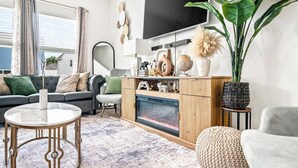 A modern living room with a sofa, coffee table, and fireplace. - The Velvet Stay (Granite Quarry)