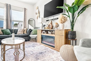 Ein modernes Wohnzimmer mit Sofa, Couchtisch und Kamin.