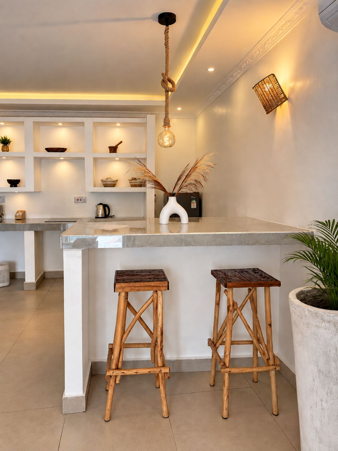 Una cocina moderna con una isla central, taburetes de madera e iluminación colgante.