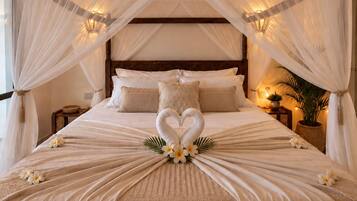 Un dormitorio con cama con dosel, ventilador de techo y un arreglo decorativo de flores y cisnes sobre la cama.