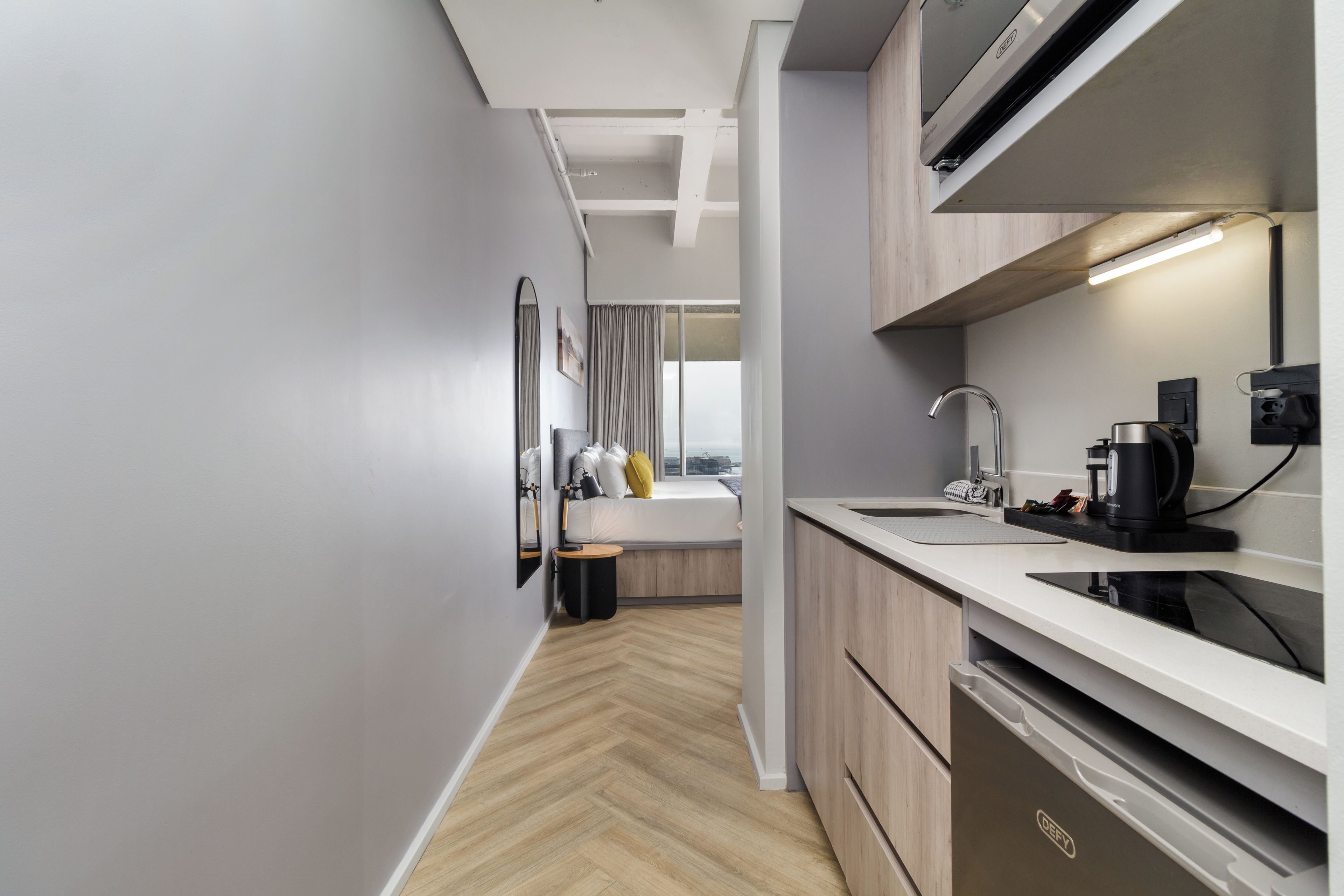 A modern kitchen with a built-in oven, a sink, and a coffee machine.