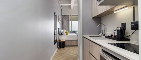A modern kitchen with a built-in oven, a sink, and a coffee machine.