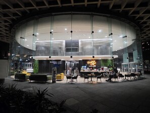 A modern building with a glass facade, a coffee shop named 'Foreshore Coffee,' and seating areas with tables and chairs. - Central CBD Apartment | Beautiful Views (Cape Town)