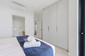 Quarto de hotel com cama, banheiro e guarda-roupa.