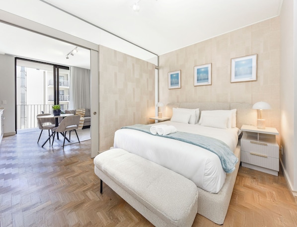 A modern bedroom with a large bed, bedside tables, a desk, and chairs. - Refined City Living with a Contemporary Soul (Johannesburg)
