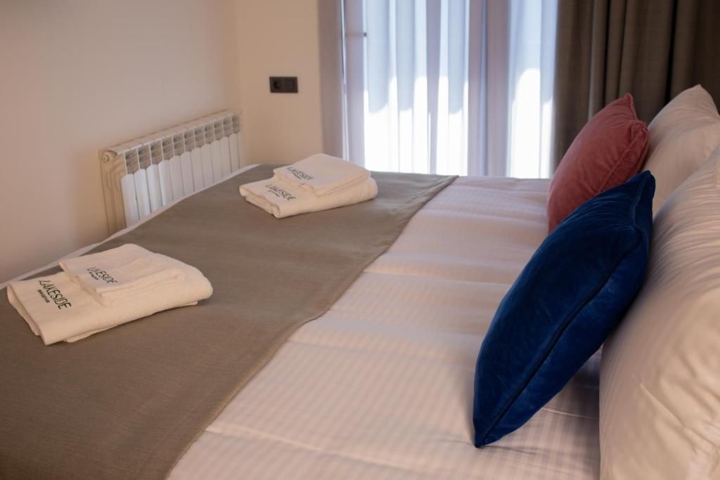 Habitación de hotel con cama, radiador y ventana con cortinas.