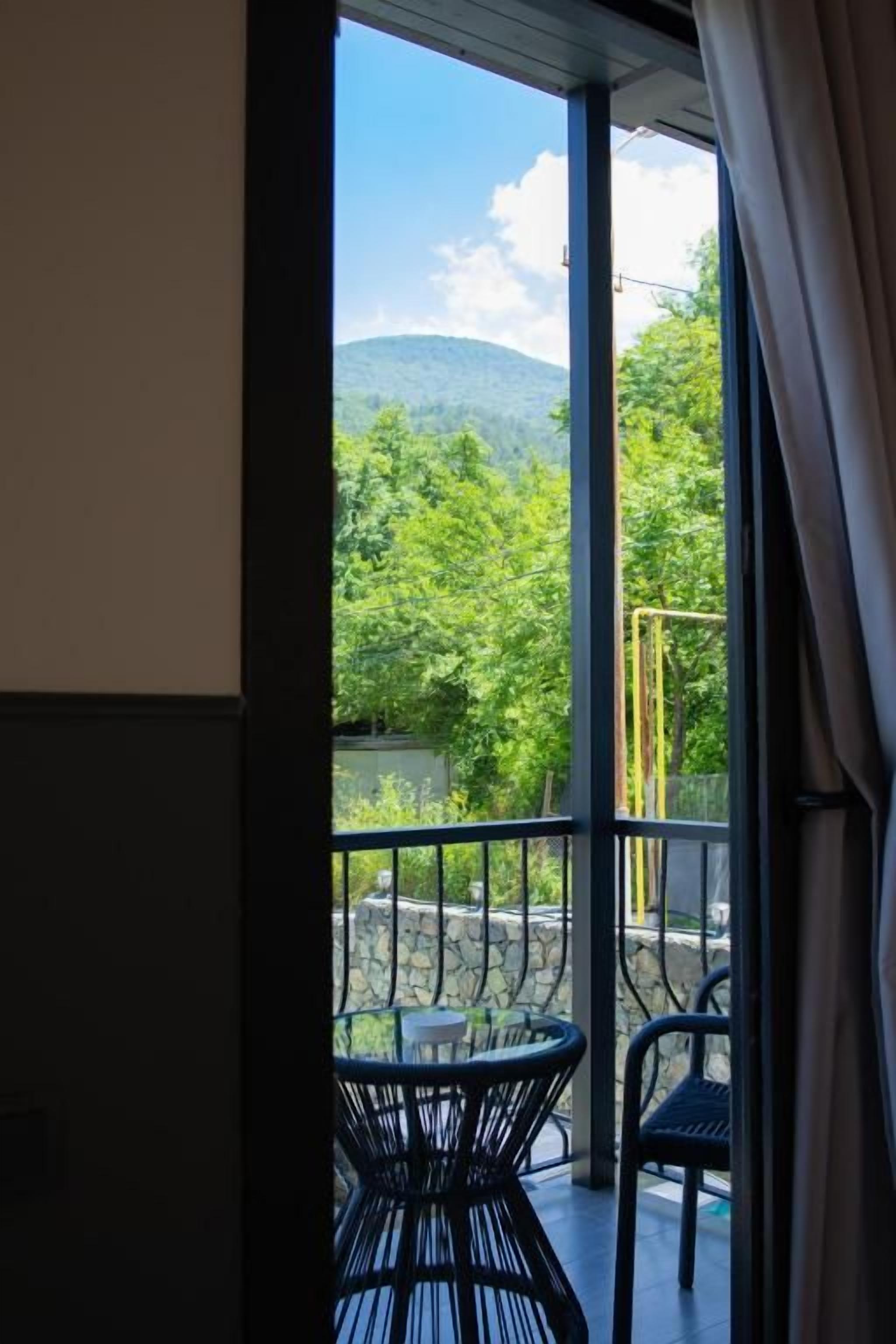 Une chambre avec un balcon, une table et des chaises.