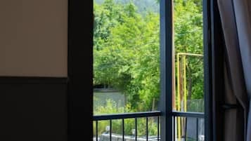 Une chambre avec un balcon, une table et des chaises.
