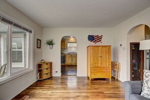 A spacious living room with hardwood flooring, a wooden cabinet, and a gray sofa. - Morning Star Cottage (Star)