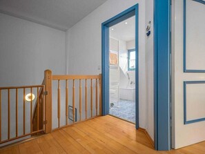 A staircase with wooden railings leading to a bathroom with a bathtub and a shower. - 11/t6 Holiday Home Park \"freesenbruch\" (Zingst)