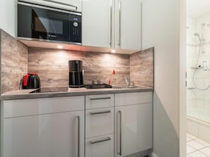 A modern kitchen with a Bosch microwave, a coffee maker, and a sink. - Utholm 3 Morning sun (St. Peter-Ording)