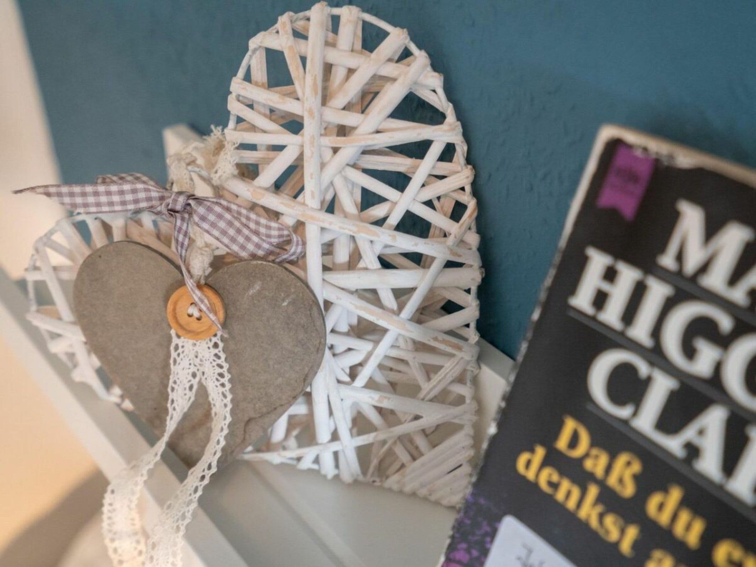 Een decoratieve wandversiering met een geweven patroon en een hartvormig object met een knoop.